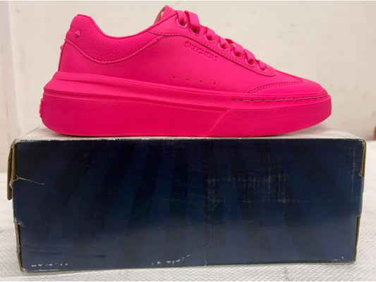 Monochromatic hot pink Skechers platform sneaker with chunky sole on blue shoebox.